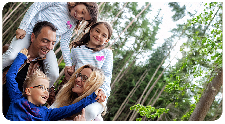Familie Wittmann, die Gründerfamilie von Mawi-Spiele, lacht gemeinsam mit ihren Kindern im Wald